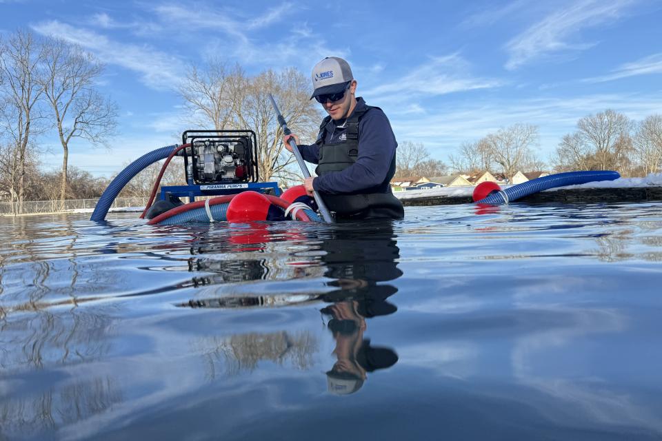 A biologists uses a small, floating hydraulic dredger to target muck on the bottom of a pond