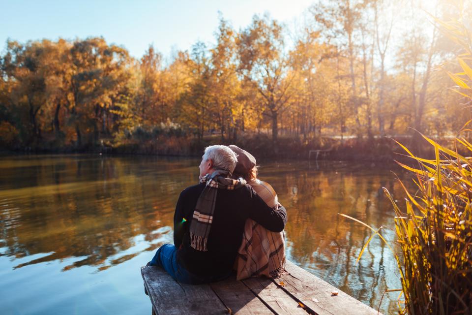 Couple relaxing and enjoying beautiful autumn day at their pond